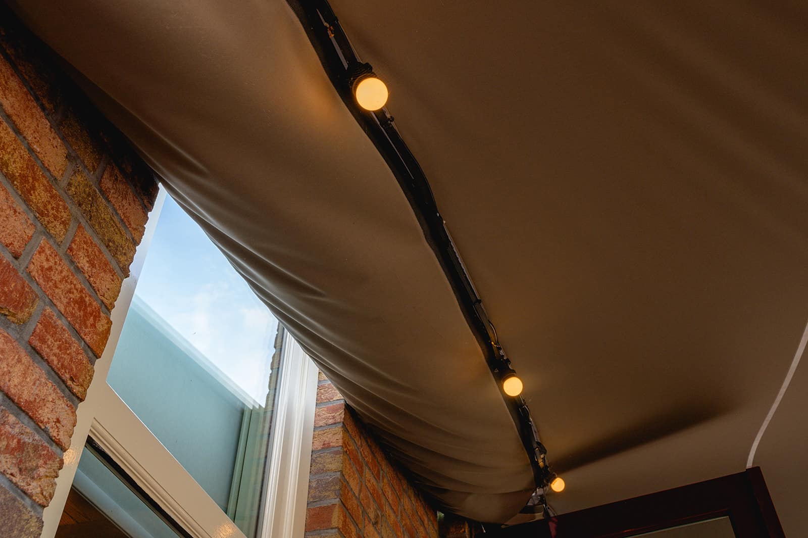 Gootsysteem tussen een stretchtent en een gevel van een pand om een waterdichte verbinding te creëren. Ideaal bij het overkappen van een terras.