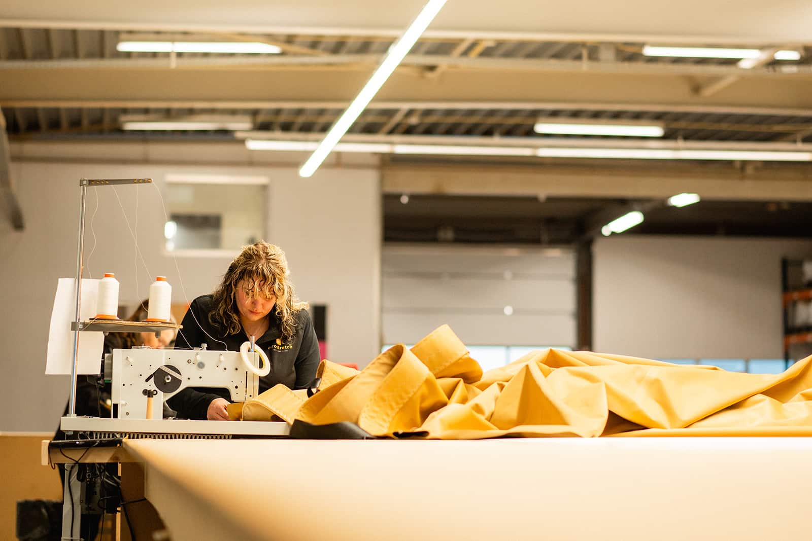 Confectiemedewerker aan tafel met een grote zandkleurige stretchtent