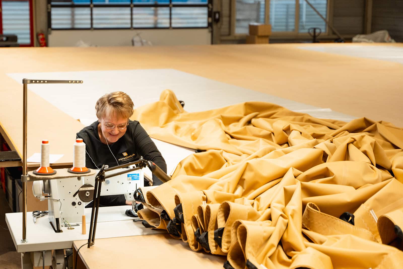 Confectiehal bij Eurostretch waar een confectie medewerker een stretchtent in elkaar zet met de naaimachine bij Eurostretch.