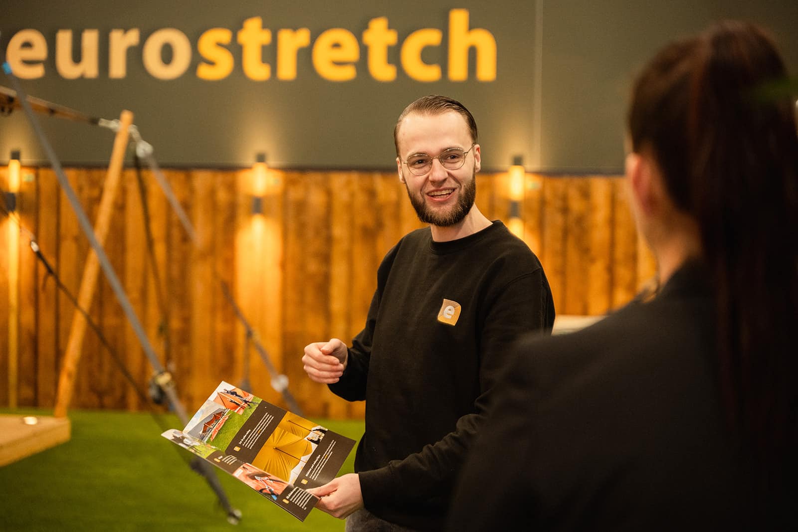 Jurrian laat handleiding zien aan klant in de stretchtenten showroom